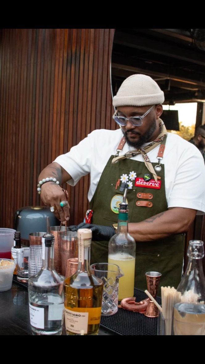 A professional mobile bartender serving festive, seasonal cocktails at an upscale holiday gathering.